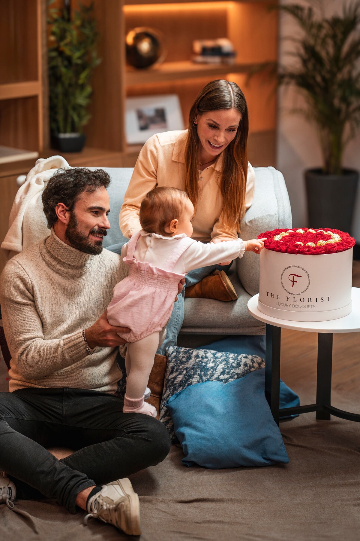 Família com caixa de rosas vermelhas The Florist