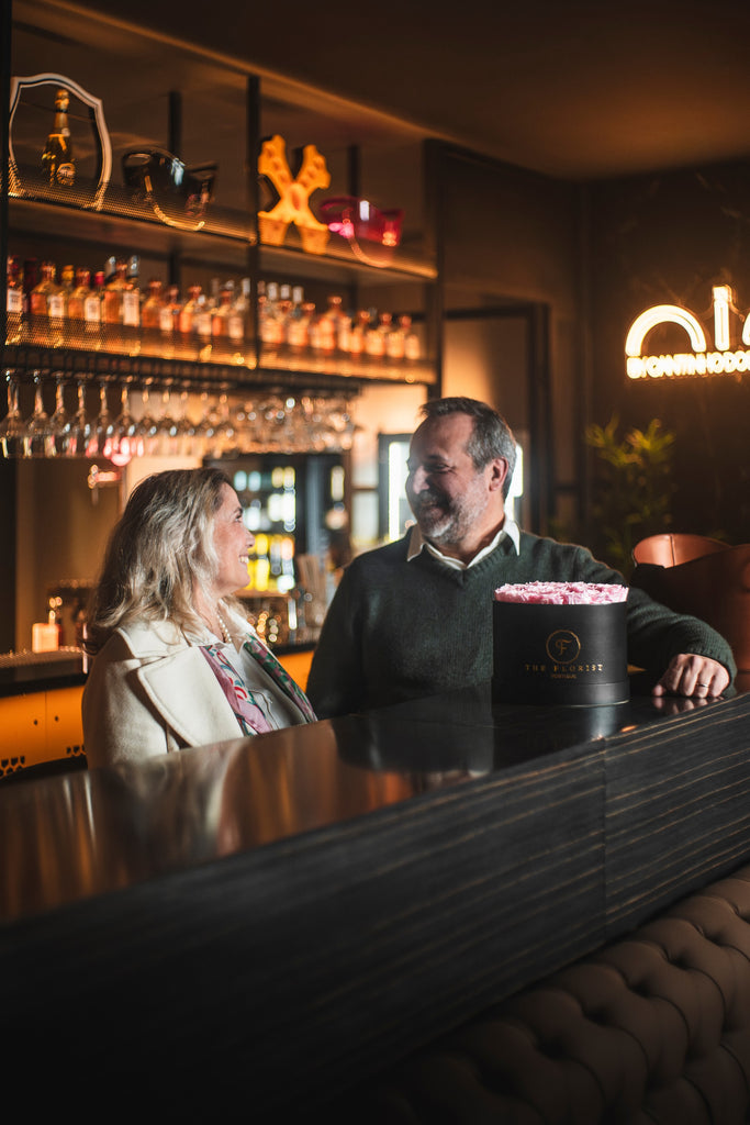 Casal num bar com caixa de rosas The Florist