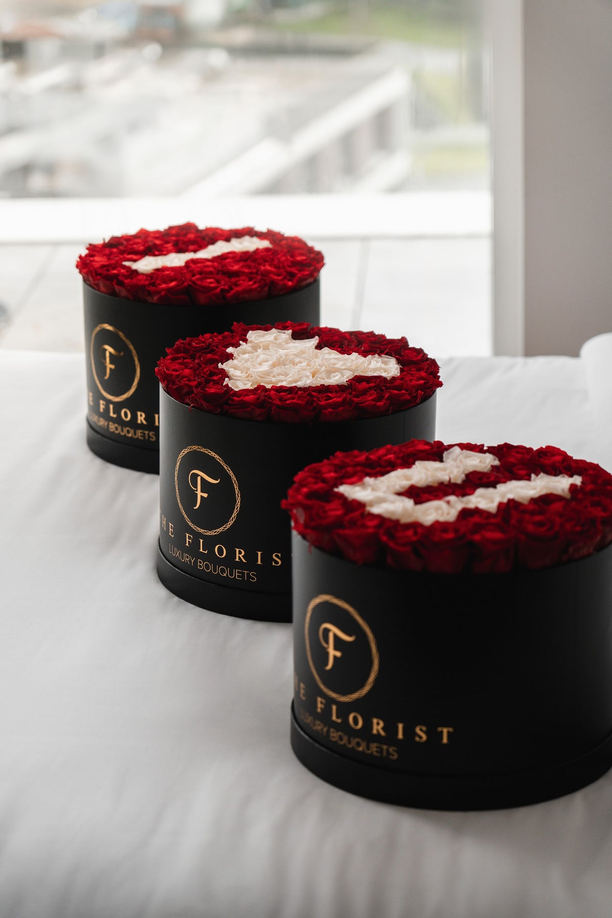 Três caixas pretas de rosas vermelhas The Florist